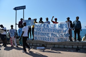 Migrants protest along the sea front at the border between Italy and France