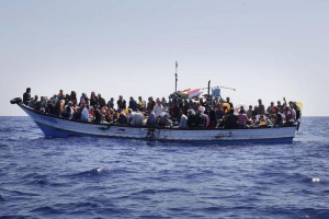 Profughi a bordo di un barcone al largo della Libia, mentre vengono soccorsi dall'equipaggio della Fregata Euro. 30 Agosto 2014. ANSA/GIUSEPPE LAMI