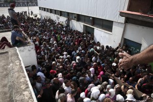 Hundreds of migrants gather for a registration procedure at the stadium of Kos town, on the southeastern island of Kos, Greece, Tuesday, Aug. 11, 2015. (ANSA/AP Photo/Yorgos Karahalis)