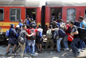 Migrants push each other to board a train that will take them to the border with Serbia, at the railway station in the southern Macedonian town of Gevgelija, on Saturday, Aug. 15, 2015. (ANSA/AP Photo/Boris Grdanoski)