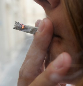 Una ragazza fuma uno spinello in una foto d'archivio. ANSA /  CLAUDIO PERI