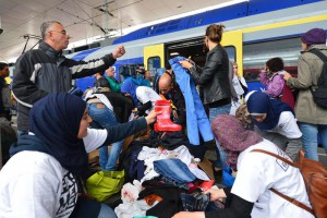 Refugees receive new clothes as they arrive at the Hauptbahnhof station in Salzburg, Austria, Saturday, Sept. 5, 2015 on their way from Hungary via Vienna to Germany. (ANSA/AP Photo/ Kerstin Joensson)