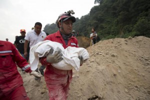 A fireman carries the body of a child recovered from the site of a landslide in Cambray, a neighborhood in the suburb of Santa Catarina Pinula, about 10 miles east of Guatemala City, Friday, Oct. 2, 2015. (ANSA/AP Photo/Moises Castillo)