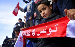A young boy holds a scarf with Arabic inscription reading Tunisia during a demonstration against the visit of Tunisian President Moncef Marzouki on the second anniversary of the Tunisian revolution, in Sidi Bouzid, south Tunisia, 17 December 2012.  ANSA/STR