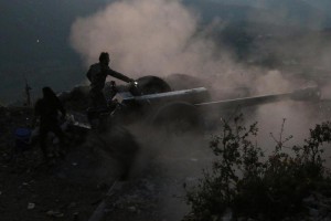 In this photo taken on Saturday, Oct. 10, 2015, Syrian army personnel operate a cannon in Latakia province, about 12 from the border with Turkey in Syria. Backed by Russian airstrikes, the Syrian army has launched an offensive in central and northwestern regions. (Alexander Kots/Komsomolskaya Pravda via AP)
