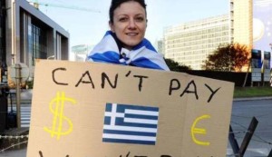 A Protestor holds a placard with a Greek flag during a demonstration outside of an EU summit in Brussels on Sunday, Oct. 23, 2011. (AP Photo/Geert Vanden Wijngaert)