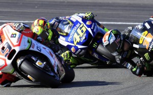 MotoGP rider Valentino Rossi of Italy steers his motorcycle between Danilo Petrucci of Italy, left, and Bradley Smith of Britain, right, during the Valencia Motorcycle Grand Prix, the last race of the season, at the Ricardo Tormo circuit in Cheste near Valencia, Spain, Sunday, Nov. 8, 2015. (ANSA/AP Photo/Alberto Saiz)