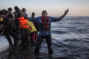 A young man gestures after disembarking from a dinghy at a beach on the Greek island of Lesbos after crossing the Aegean sea from the Turkish coast, Saturday, Nov. 14, 2015. (ANSA/AP Photo/Santi Palacios)