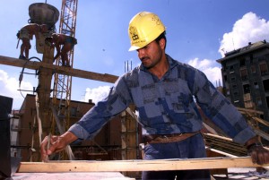 Un operaio egiziano al lavoro in un cantiere nel centro di Milano in una foto d'archivio. ANSA / DANIEL DAL ZENNARO