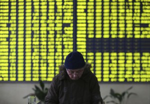 A stock investor pauses near a display board showing stock prices in green to symbolize a fall in price at a brokerage house in Jiujiang in central China's Jiangxi province Monday Jan. 4, 2016. (Chinatopix Via AP) CHINA OUT