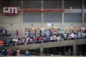 People queue up outside a supermarket in Caracas on January 13, 2015. AFP PHOTO/FEDERICO PARRA