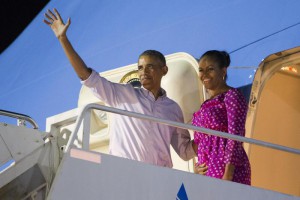 President Barack Obama, left, and first lady Michelle Obama wave as they board Air Force One to depart from Joint Base Pearl Harbor-Hickam at the end of their family vacation, on Saturday, Jan. 2, 2016, in Honolulu, Hawaii. (ANSA/AP Photo/Evan Vucci)