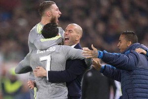 Real Madrid's Cristiano Ronaldo (C) celebrates with his teammate Sergio Ramos (L) and his head coach Zinedine Zidane (R) after scoring the 0-1 goal during the UEFA Champions League Round of 16 first leg soccer match between AS Roma and Real Madrid CF at the Olimpico stadium in Rome, Italy, 17 February 2016.. ANSA/CLAUDIO PERI