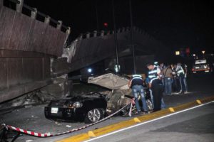 Members of Ecuadoran emergency services check a car after a bridge collapsed due to a 7.8 magnitude earthquake, in the city of Guayaquil, Ecuador, late 16 April 2016. EPA/FREDDY CONSTANTE