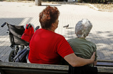 Badante con una signora anziana sedute in una panchina. Lavoro