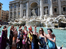 Turiste fanno un selfie mentre gettano la tradizionale monetina nella Fontana di Trevi a Roma. Tassa