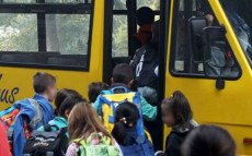 Bambini si accalcano sulla porta dello scuolabus.