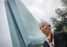 In una foto d'archivio Christine Lagarde , presidente della Bce di fronte alle torri sede dell'istituto.
