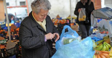 Una anziana paga la frutta acquistata in un mercato a Pisa in una foto d'archivio