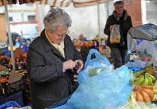 Una anziana paga la frutta acquistata in un mercato a Pisa in una foto d'archivio