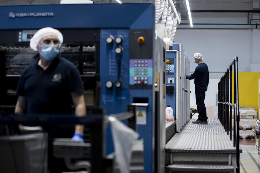 Dipendenti indossano mascherine e guanti protettivi a prevenzione della diffusione del Covid-19, durante il turno di lavoro, presso lo stabilimento industriale di packaging farmaceutico Eurpack di Aprilia,