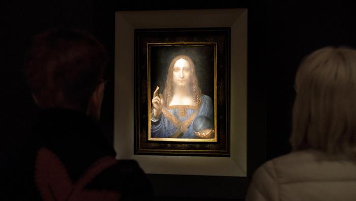 Persone ammirano il Salvator Mundi di Leonardo da Vinci messo all'asta da Christie's