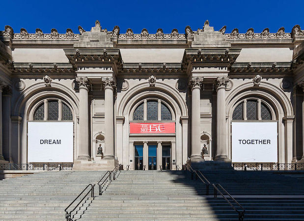 La facciata del Met a New York con gli stendardi creati da Yoko Ono.