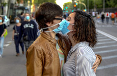 Un bacio con la mascherina protettiva.