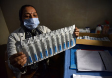 Un assistente sanitario sostiene le siringhe con il vaccino contra il Covid-19 durante un operativo di vaccinazione nell'ospedale di Jammu, India,