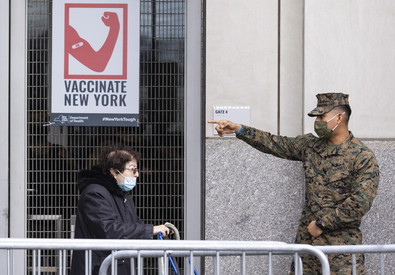 La Guardia nazionale allo Yankees Stadium New York indica a una donna lo sportello per la vaccinazione