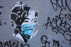 Murale con un disegno di donna con mascherina.