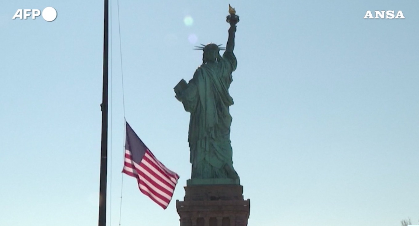 La statua della Libertà e la bandiera americana a mezz'asta