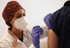 Un infermiera somministra un vaccino.
