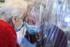 Nella Rsa di Castelfranco Veneto abbracci tra due anziane protette da un velo di plastica.