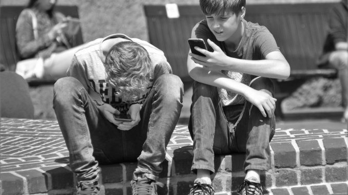 Adolescenti giocando con lo smartphone.