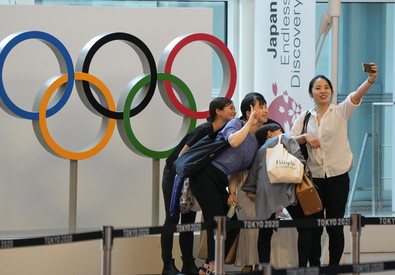 Un gruppo di giovani si fa una selfie davanti ad una insegna delle olimpiade.