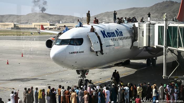 Esuli afghani salgono inn un aereo a Kabul.