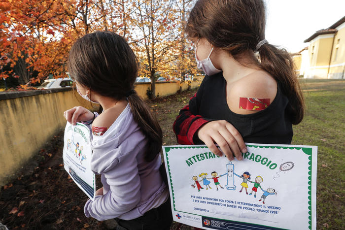 Due bambine vaccinate nell'ospedale Lazzaro Spallanzani mostrano il certificato verde.