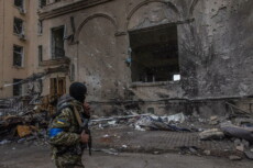Un militare delle forze ucraine di fronte ad un edificio distrutto dai bombardamenti russi a Kharkiv