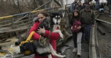 Una donna fugge con il cane in braccio da Kiev. (ANSA)